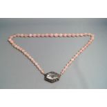 A rose quartz bead necklace, with an engraved rock crystal set clasp,