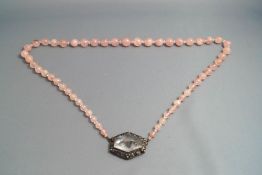 A rose quartz bead necklace, with an engraved rock crystal set clasp,