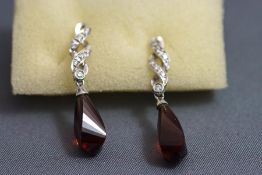 A pair of continental drop earrings, the facetted stone, possibly rubellite,