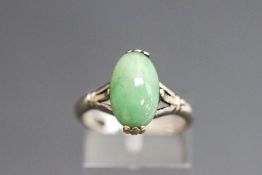 A jade ring, the white mount stamped '18K', the oval cabochon, approximately 12mm long by 7.