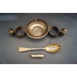 A silver two handled pierced bowl; two silver napkin rings; and a silver cheroot holder case;