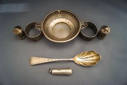 A silver two handled pierced bowl; two silver napkin rings; and a silver cheroot holder case;