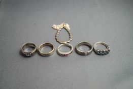 A collection of five silver and silver coloured rings;