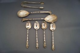 A pair of silver small berry spoons; a pair of sugar tongs;