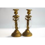 A pair of Regency style gilt metal candlesticks, modelled as Classical maidens, with lustre drops,