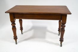 A Victorian mahogany rectangular table, on turned legs with brass,