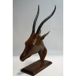 An African carved gazelle head with cast metal horns,