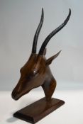 An African carved gazelle head with cast metal horns,