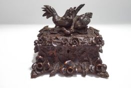 An oak 'Black Forest' style box, the lid carved as a family of chickens amongst a floral design,