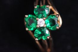 A 9 carat gold Shamrock ring, set with four green pastes and a small central stone,