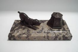 An Art Deco style marble and pewter desk stand, modelled with a dog and inkwell,