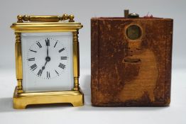 A brass cased carriage clock with leather travelling case and key,