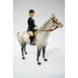 A Beswick figure of a hunting lady on a grey, printed mark,