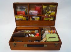 A large fly tying box with quantities of hooks, yarn, fur,