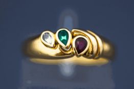 A three stone diamond, emerald and ruby ring, stamped '750', finger size L, 4.