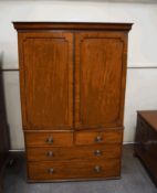 A George III mahogany linen press, the cupboard doors enclosing four trays, over a four drawer base,