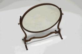 An Edwardian oval mahogany swing frame dressing table mirror,