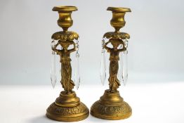 A pair of Regency style gilt metal candlesticks, modelled as Classical maidens, with lustre drops,