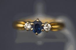 An 18 carat gold three stone sapphire and diamond ring,
