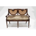 A Regency style mahogany double chair back sofa, with cane seat and back panels,