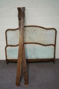 A French style double bed, with patterned upholstered head and foot boards,