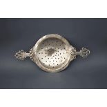 An Arts and crafts silver tea strainer, by CJP, London 1909, with wire work handles, 14 cm across,