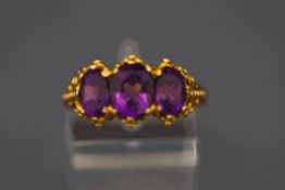 A 9 carat gold three stone amethyst ring, in the Victorian style, finger size N, 4.