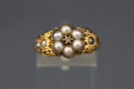 A Victorian mourning ring, the split pearl cluster around a silver collet set rose cut diamond,
