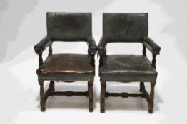 A pair of early 19th century oak armchairs, with green leather upholstery, reputedly,