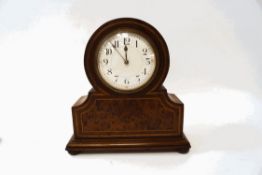 An early 20th century mantel clock, with burr walnut inlaid panel and ropetwist inlay, on bun feet,