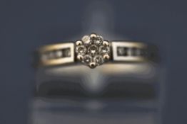 A diamond cluster ring, the white mount tagged '18K',