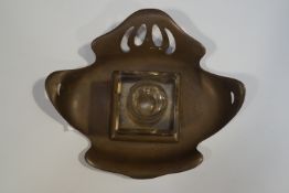 An Art Nouveau brass inkwell stand, with glass square inkwell, stamped Ges Gesch,