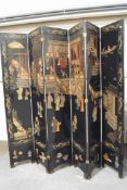 A 20th century Japanese six-fold ebonised room screen, decorated with figures of musicians,