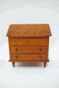 A leather jewellery box in the form of a bureau with two drawers on square tapering legs, 24.