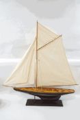 A model yacht in full sail, on stand,