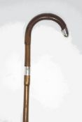 A walking stick with silver collar and tip,