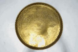 A large round brass tray engraved with Egyptian motifs,