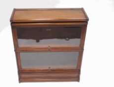 A Globe Wernicke mahogany bookcase, comprising a base, two tiers and a top, with labels to back,