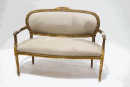 A Louis XVI style sofa with carved wood and gilded frame on fluted tapering legs,