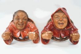 A pair of Austrian earthenware wall mounted candle holders, modelled as monks,