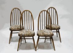An Ercol set of four light wood stick back kitchen chairs