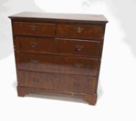 A George III walnut chest of two short and three long drawers, with brass handles and bracket feet,
