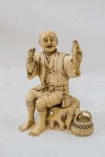 An early 20th century Japanese carved ivory figure of a fisherman,