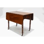 A Victorian mahogany pembroke table on ring turned legs and brass casters,
