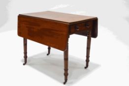 A Victorian mahogany pembroke table on ring turned legs and brass casters,