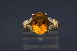 A citrine and diamond 9 carat gold ring, the oval cut with single cuts to the shoulders,