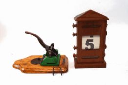 A mahogany desk calendar with rolling day, date and month,