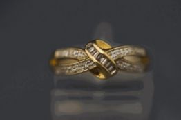 A 9 carat gold diamond set kiss style ring, set with baguettes and single cuts,