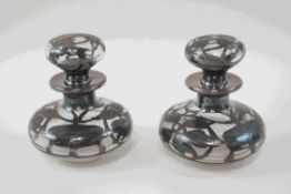 A pair of silver overlaid glass scent bottles and stoppers,