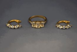 A 9 carat gold three stone dress ring with diamond set shoulders;
